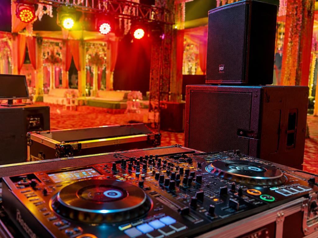 DJ console and speakers set up at a decorated celebration venue