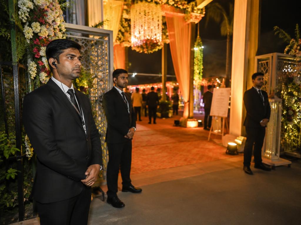 Event security staff in black suits at a decorated venue entrance